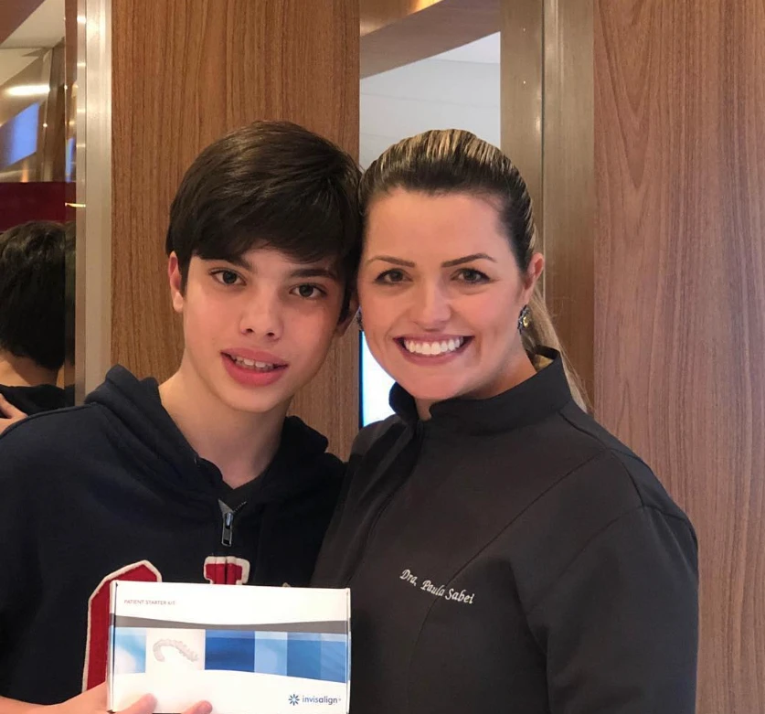 Paciente adolescente recebendo o kit Invisalign com a Dra. Paula